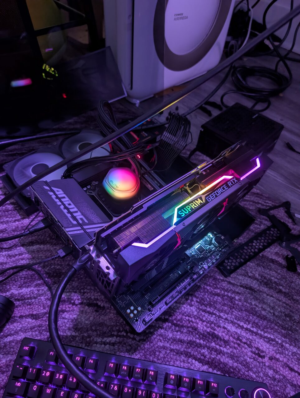 A motherboard and graphics card lit by purple LEDs